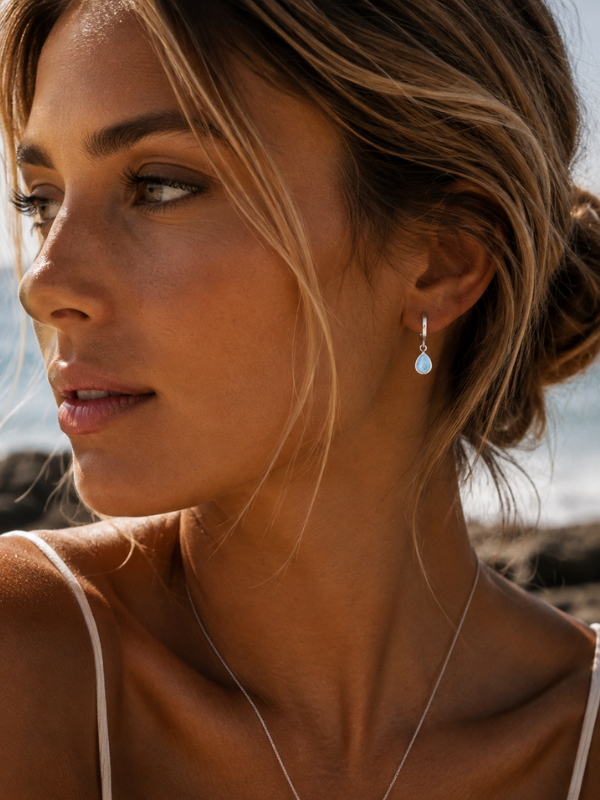 925 sterling silver huggie earrings featuring teardrop-shaped natural Larimar stone with unique ocean-blue colouring.